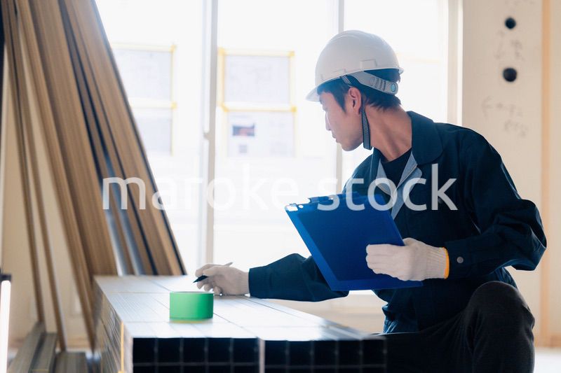 建設現場で資材の確認をする大工