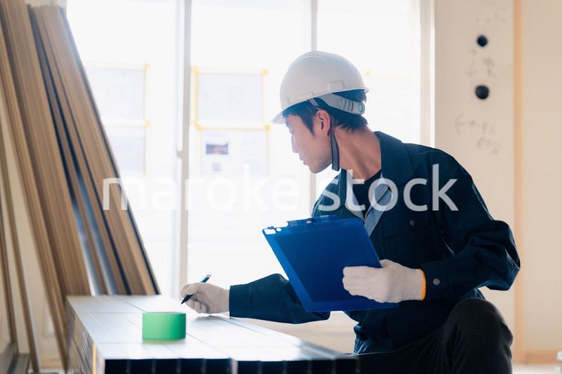 建設現場で資材の確認をする大工