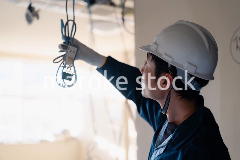 建築現場で配線工事をする電気工事士