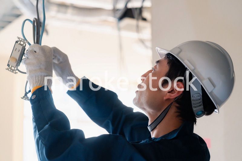 建築現場で配線工事をする電気工事士