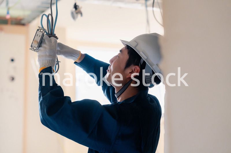 建築現場で配線工事をする電気工事士