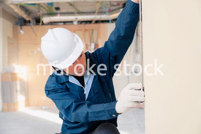 建設現場で採寸をする大工さん