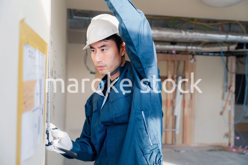 建設現場で採寸をする大工さん