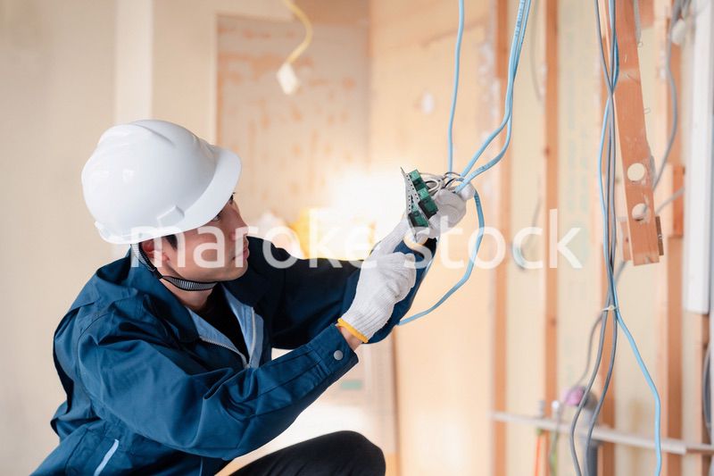 建築現場で配線工事をする電気工事士