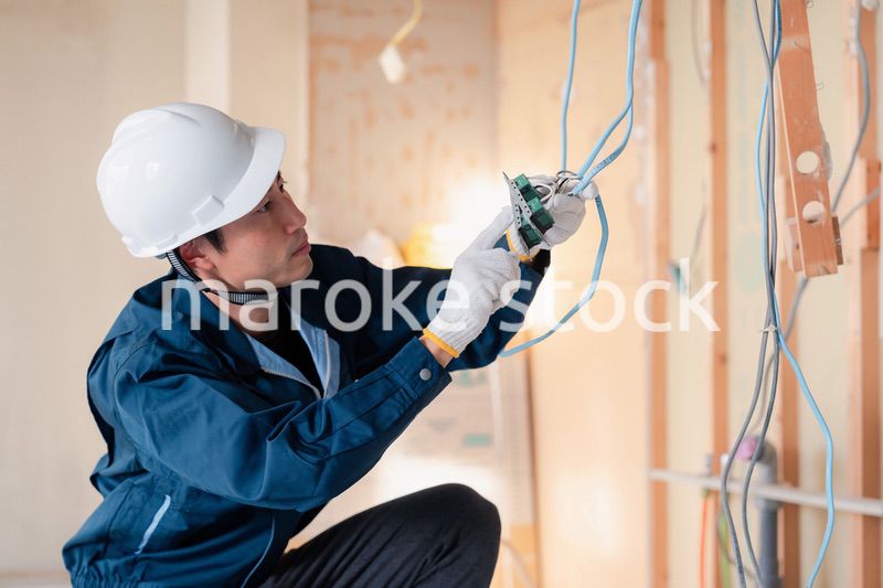 建築現場で配線工事をする電気工事士