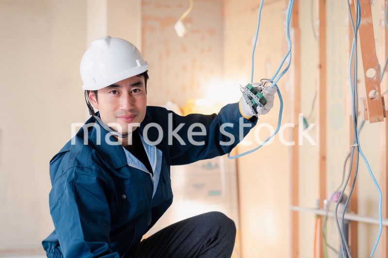 建築現場で配線工事をする電気工事士