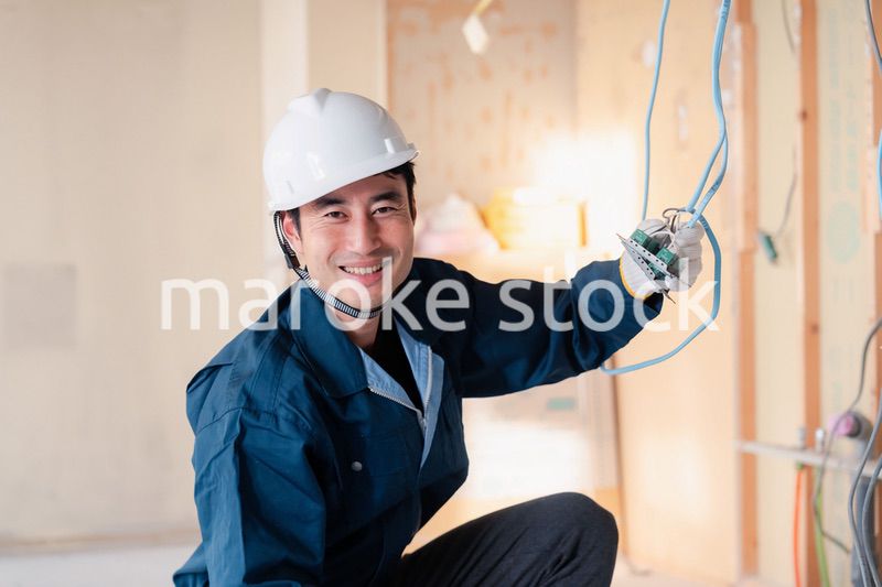 建築現場で配線工事をする電気工事士