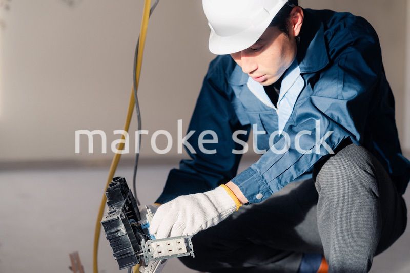 建築現場で配線工事をする電気工事士