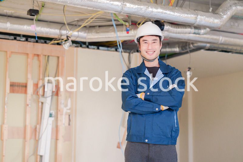 工事現場で腕を組む男性の職人