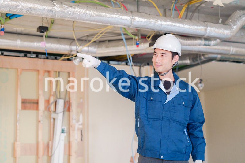 指差しをして安全確認をする男性の建築作業員