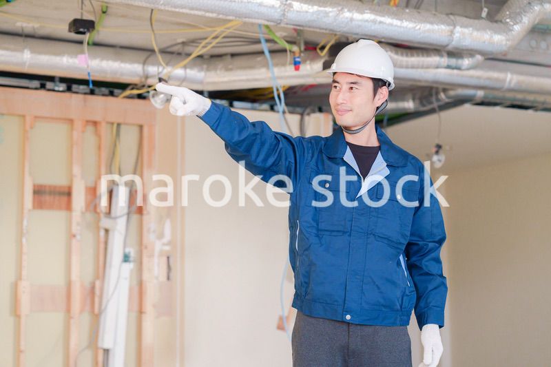 指差しをして安全確認をする男性の建築作業員