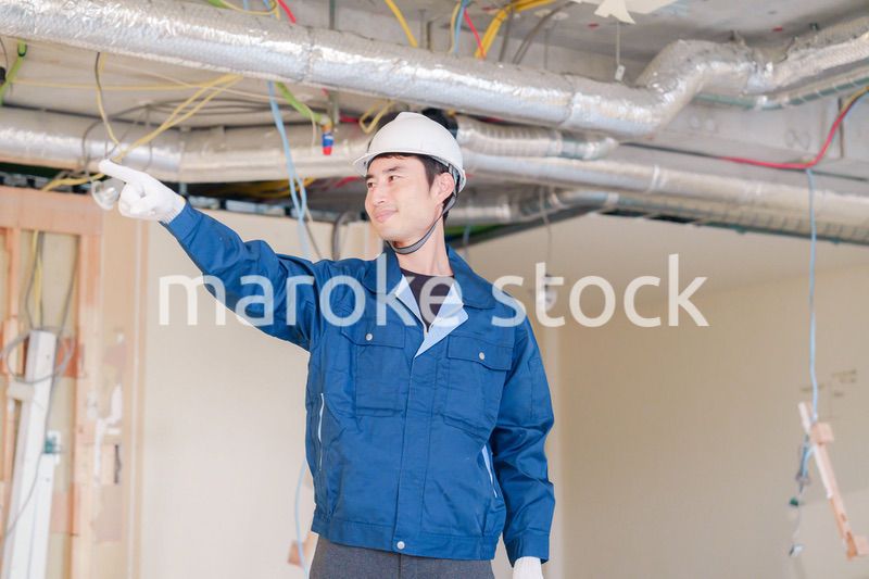 指差しをして安全確認をする男性の建築作業員