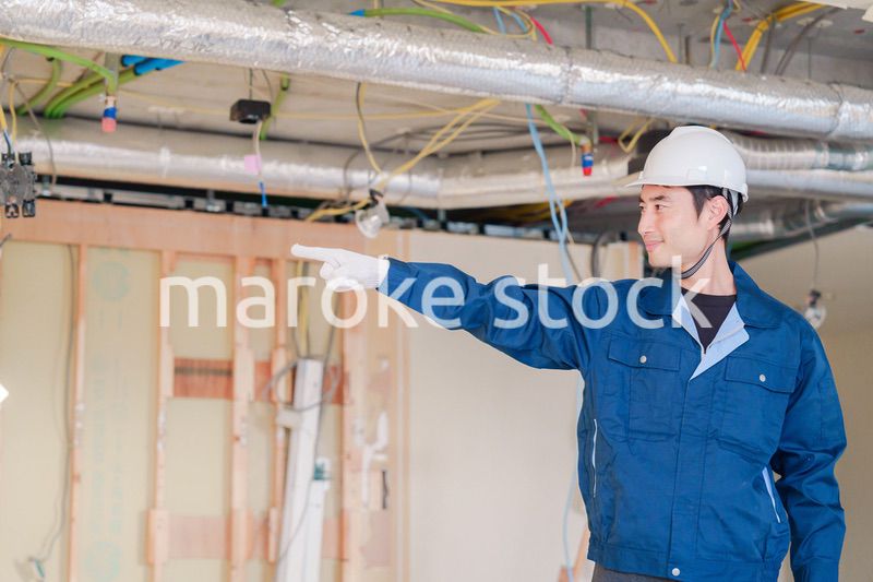 指差しをして安全確認をする男性の建築作業員