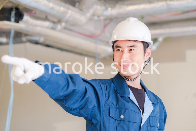 指差しをして安全確認をする男性の建築作業員