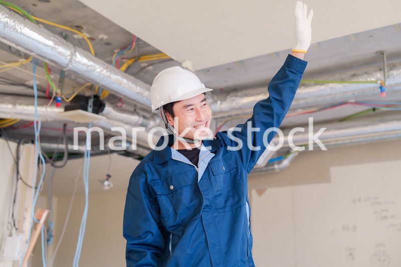 工事現場で楽しく働く職人の男性