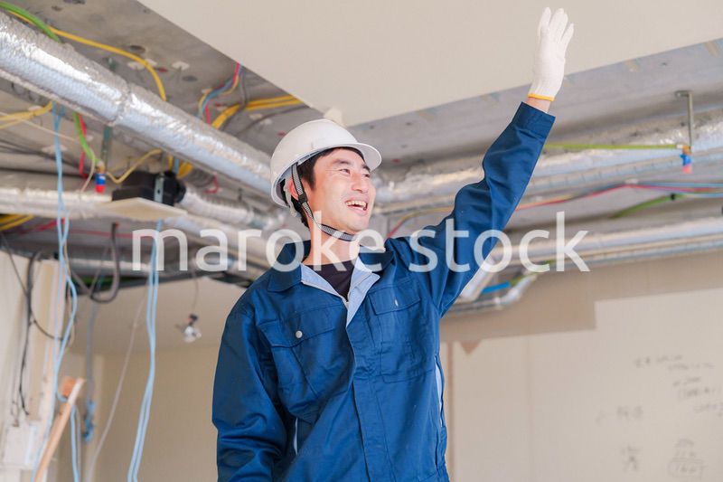 工事現場で楽しく働く職人の男性