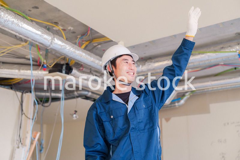 工事現場で楽しく働く職人の男性