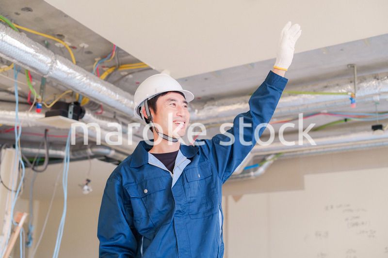 工事現場で楽しく働く職人の男性