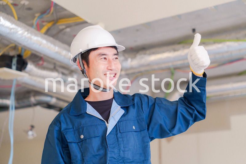 工事現場で楽しく働く職人の男性