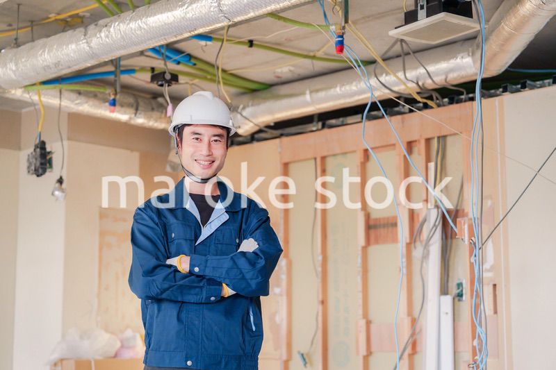 工事現場で腕を組む男性の職人