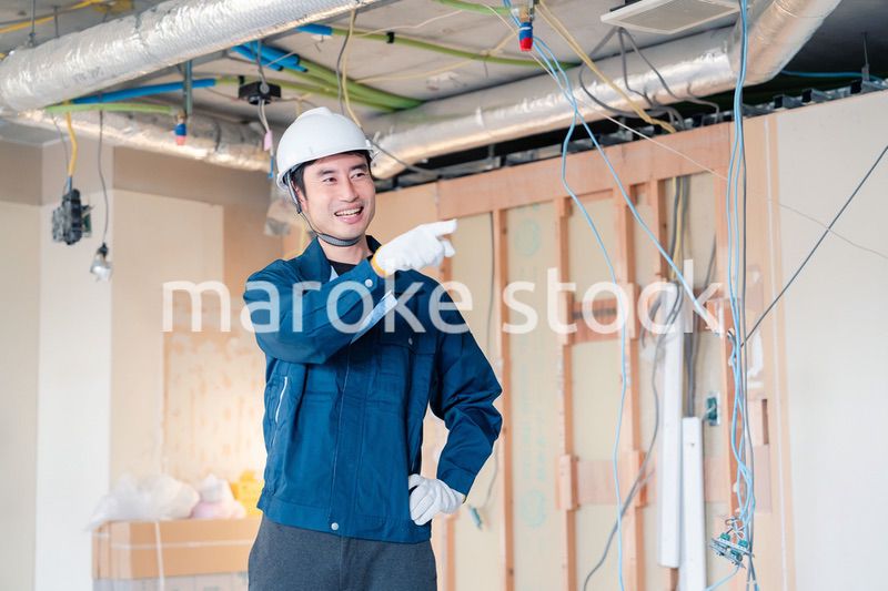 指差しをして安全確認をする男性の建築作業員