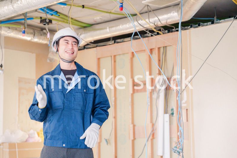 工事現場で楽しく働く職人の男性