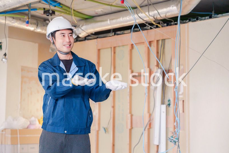 工事現場で楽しく働く職人の男性