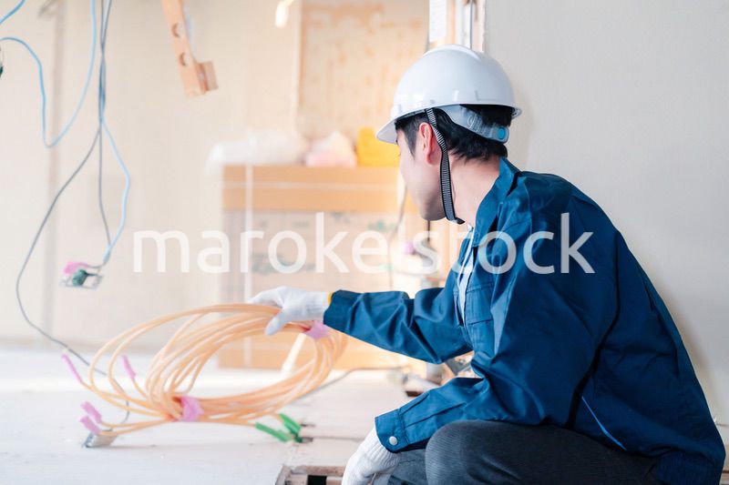 床暖房の施工をする男性の職人