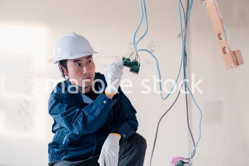 建築現場で配線工事をする電気工事士
