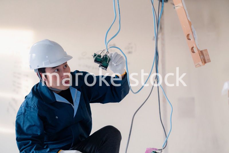 建築現場で配線工事をする電気工事士