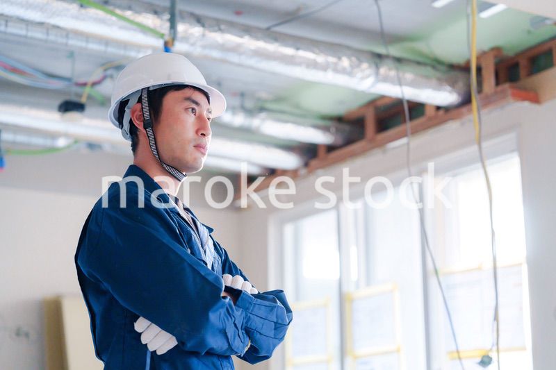 工事現場で腕を組む男性の職人