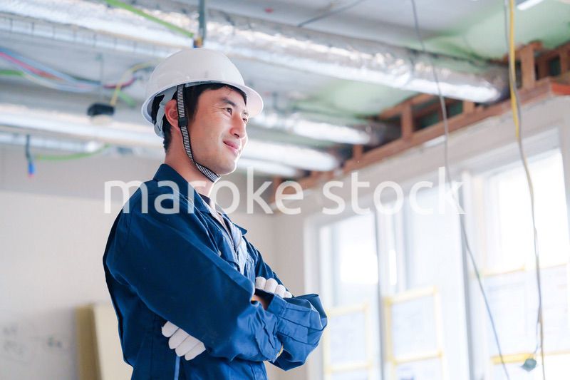 工事現場で腕を組む男性の職人