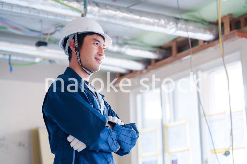 工事現場で腕を組む男性の職人