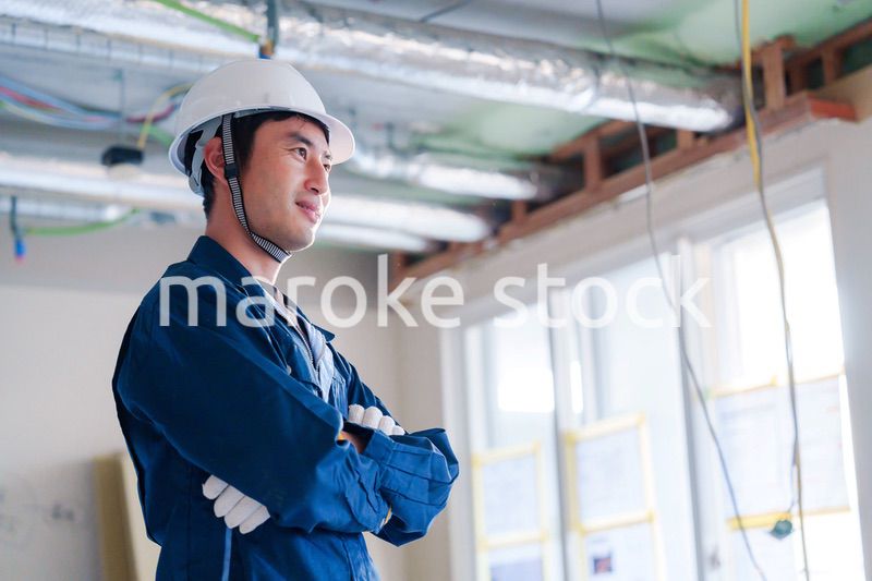 工事現場で腕を組む男性の職人