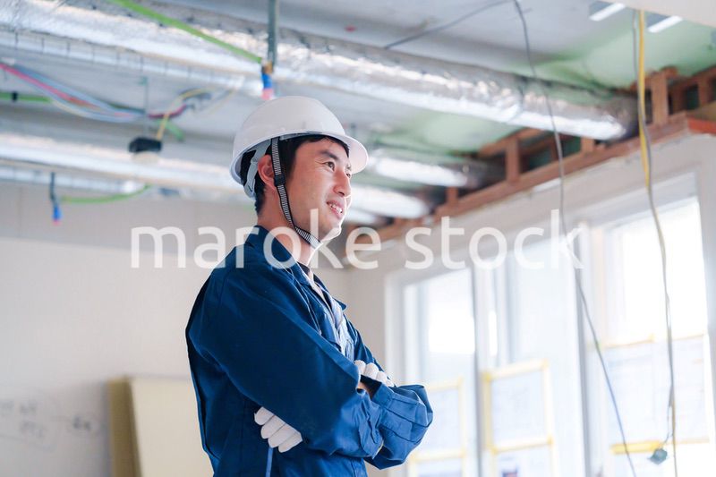 工事現場で腕を組む男性の職人