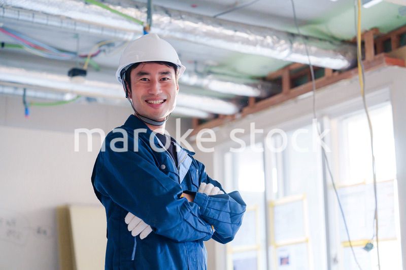 工事現場で腕を組む男性の職人