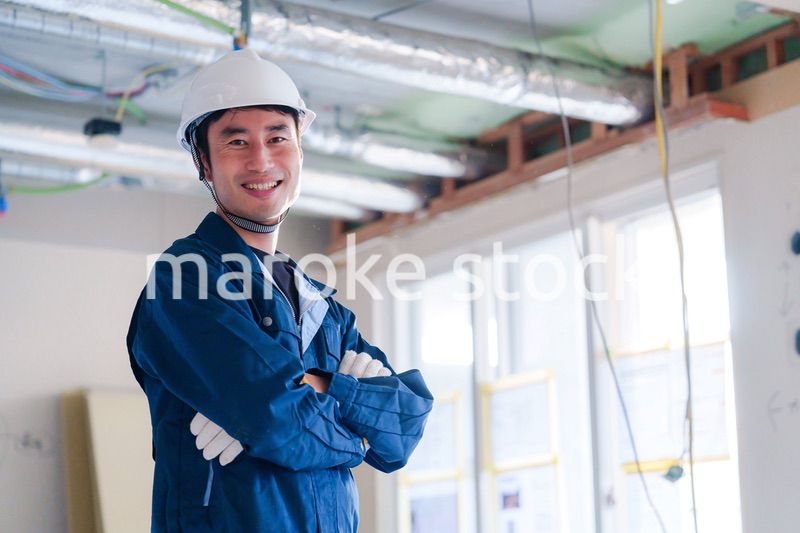 工事現場で腕を組む男性の職人