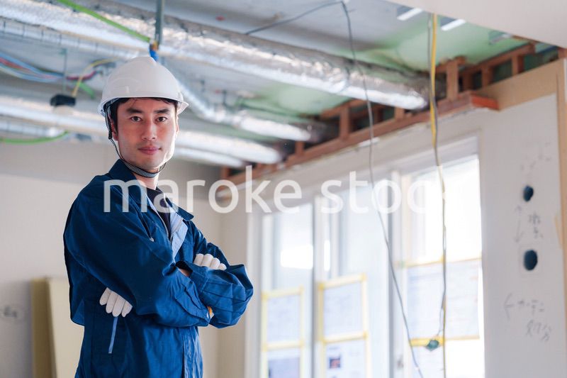 工事現場で腕を組む男性の職人