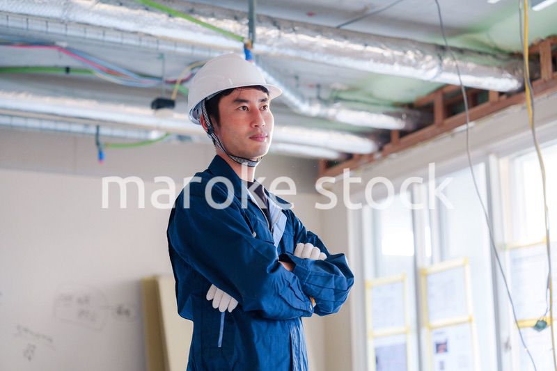 工事現場で腕を組む男性の職人