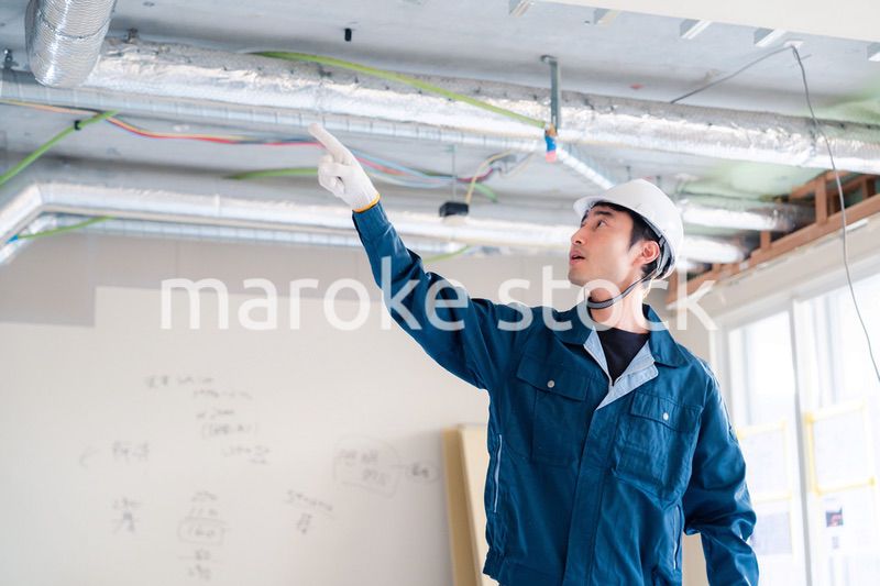 指差しをして安全確認をする男性の建築作業員