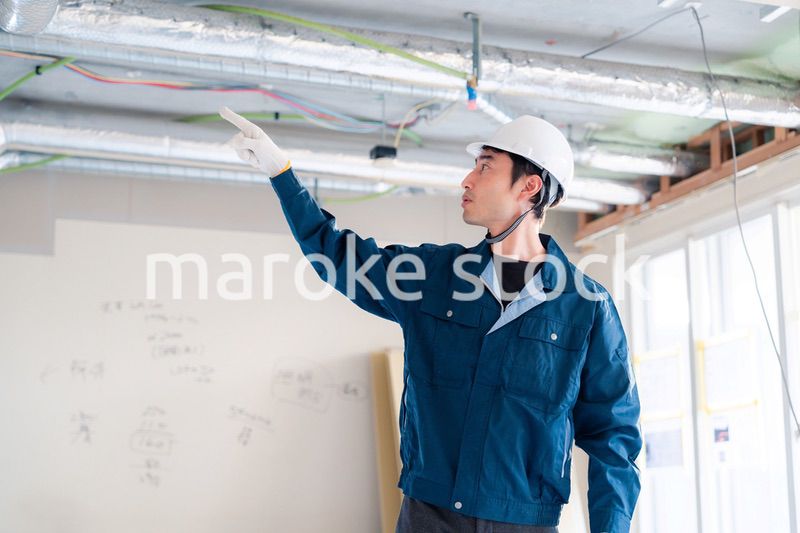 指差しをして安全確認をする男性の建築作業員