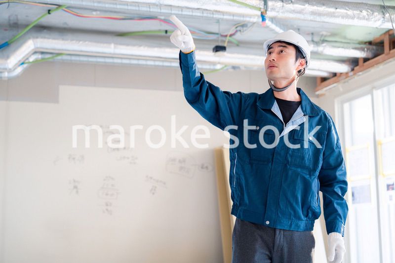 指差しをして安全確認をする男性の建築作業員