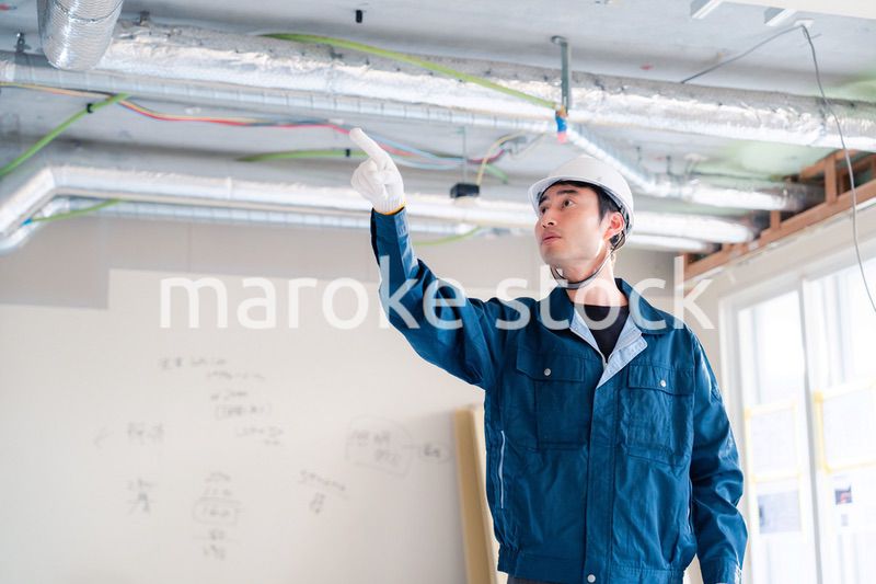 指差しをして安全確認をする男性の建築作業員