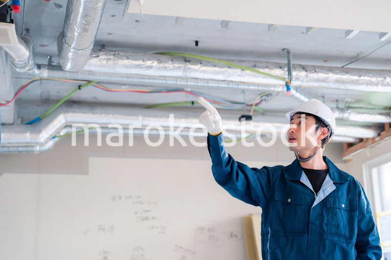 指差しをして安全確認をする男性の建築作業員