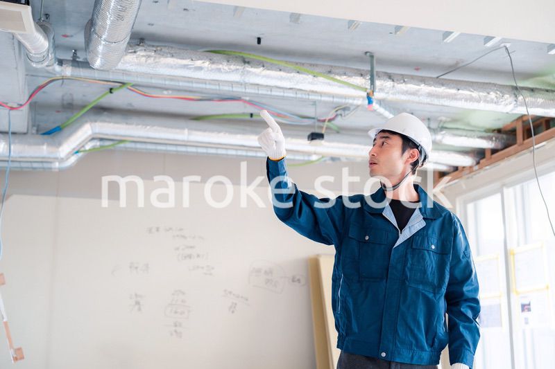 指差しをして安全確認をする男性の建築作業員