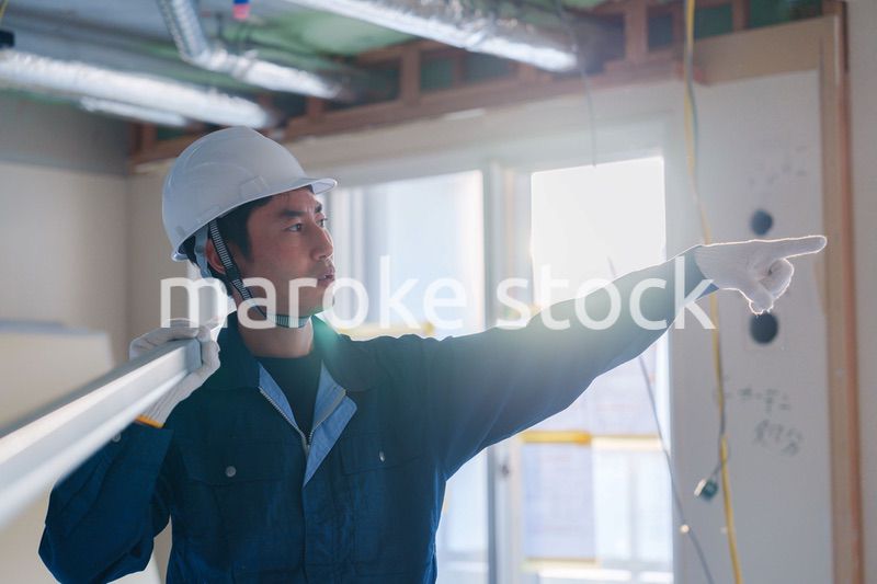 建設現場で資材を運ぶ男性の職人