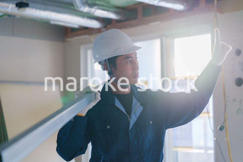 建設現場で資材を運ぶ男性の職人