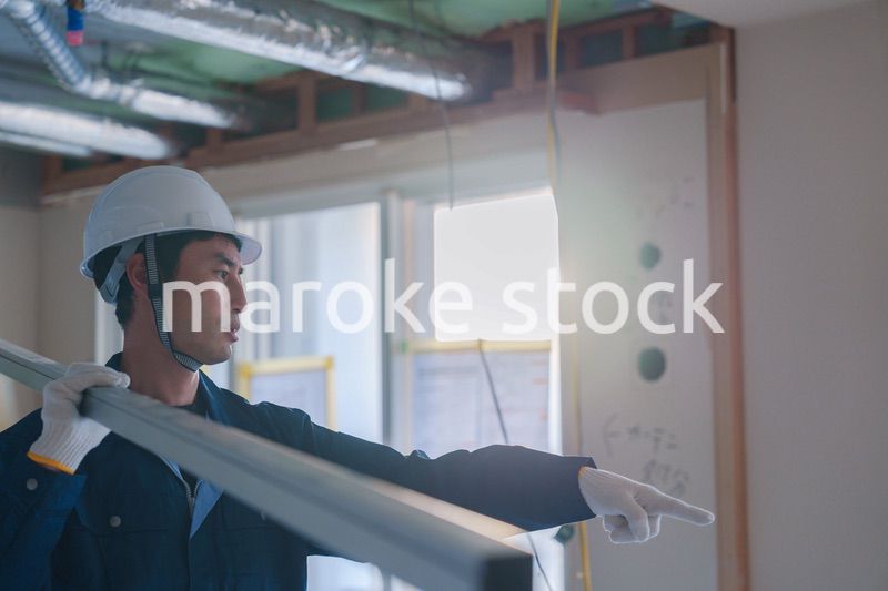 建設現場で資材を運ぶ男性の職人