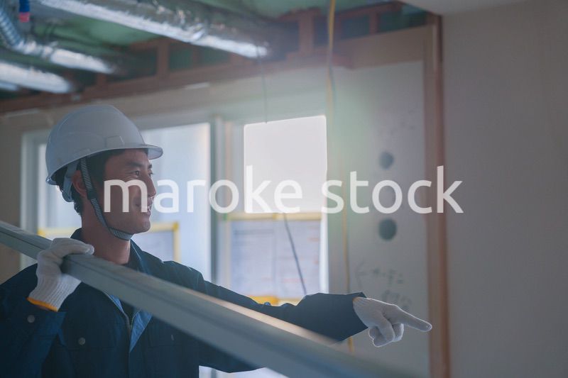 建設現場で資材を運ぶ男性の職人