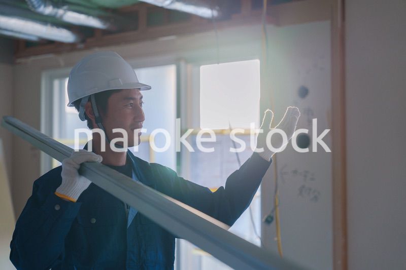 建設現場で資材を運ぶ男性の職人